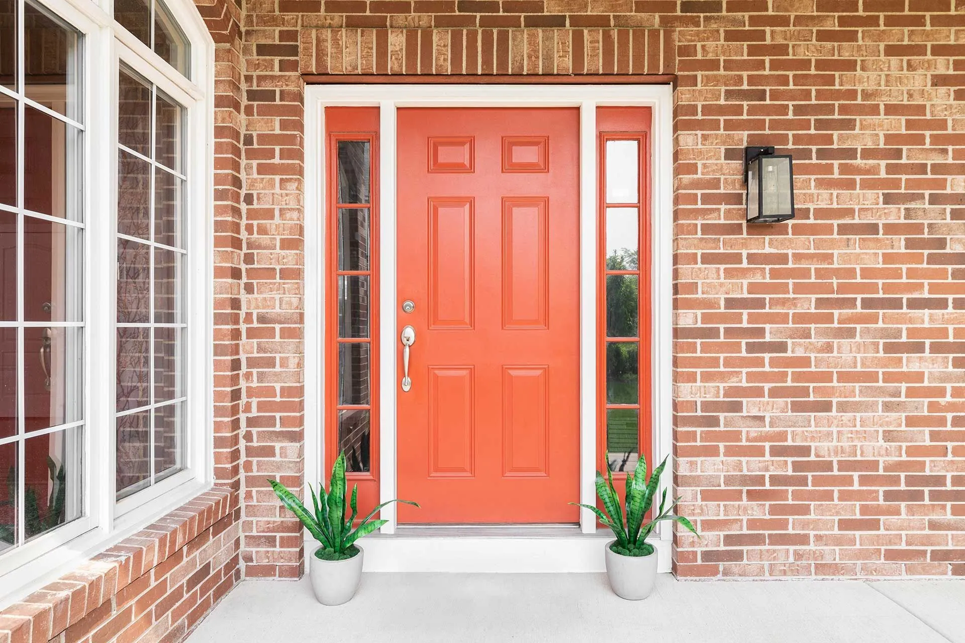 Orange entry door on brick home