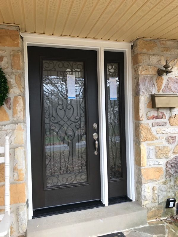 Wood entry door installation on a brick home
